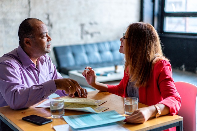 a man and a woman face each other and talking animatedly, discussing their annual IEP meeting preparations